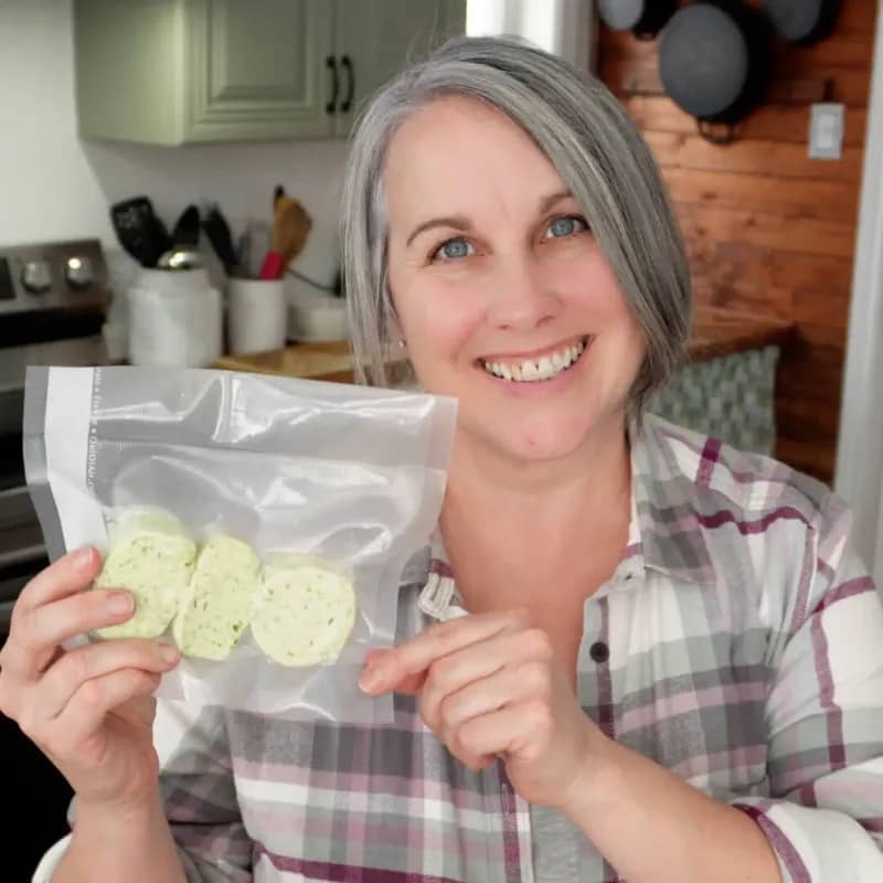 Woman holding a clear vacuum sealer bag filled with food