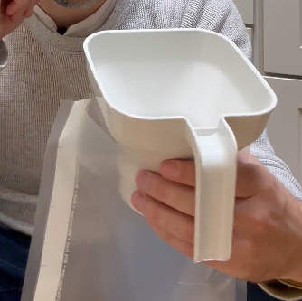 Canning funnel inserted in a vacuum sealer bag