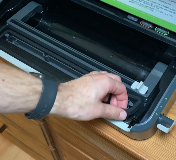 A vacuum sealer gasket being lifted out for replacement
